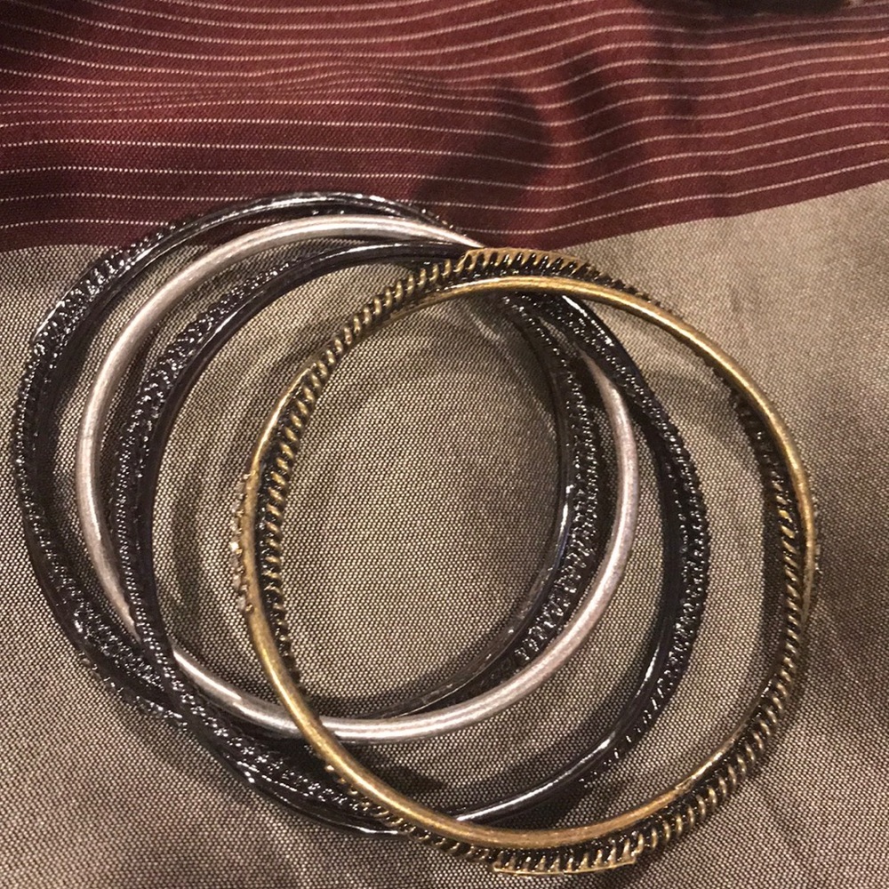 Four bracelets 2 black and 1 silver 1 gold
